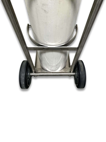 Close-up of E and G size cylinder trolley stainless steel base cradle showing cylinder seated in lower support bracket and solid rubber transport wheels
